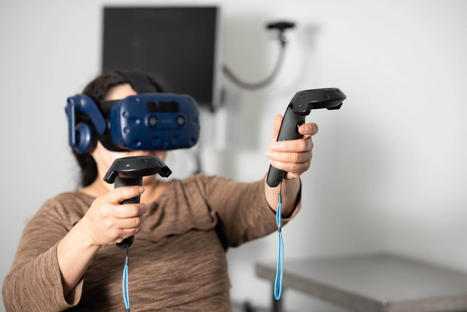Woman in a VR headset holding two controllers during Karuna Labs embodiment training